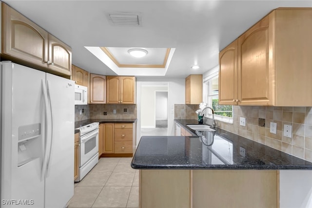 kitchen featuring white appliances, visible vents, a peninsula, a tray ceiling, and a sink