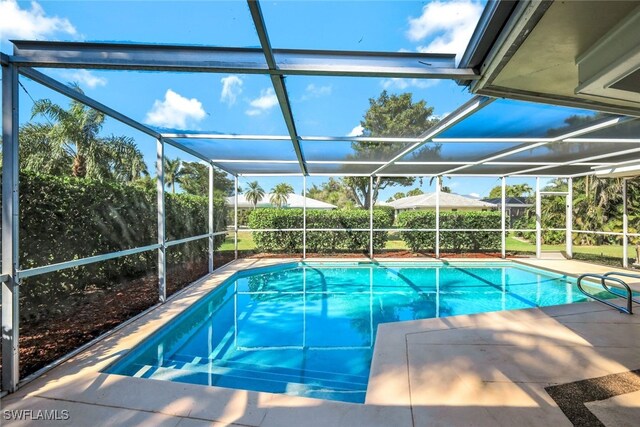 view of swimming pool with glass enclosure and a fenced in pool