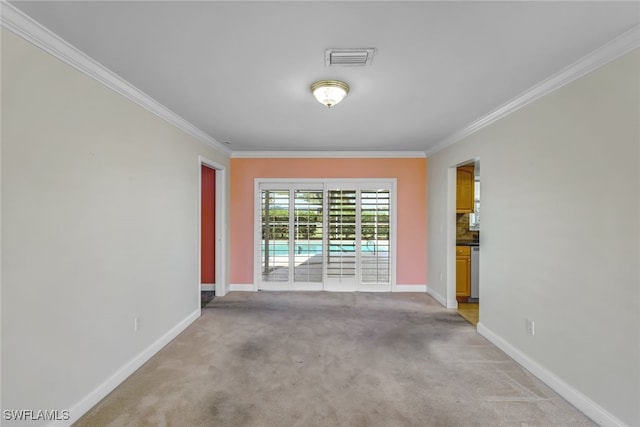 unfurnished room featuring baseboards, visible vents, and crown molding