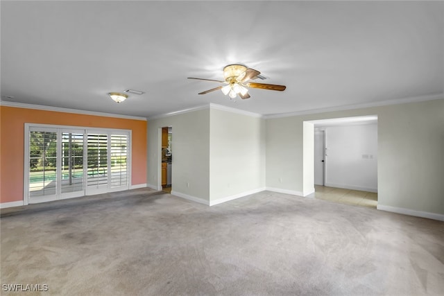 empty room featuring light carpet, baseboards, visible vents, and crown molding