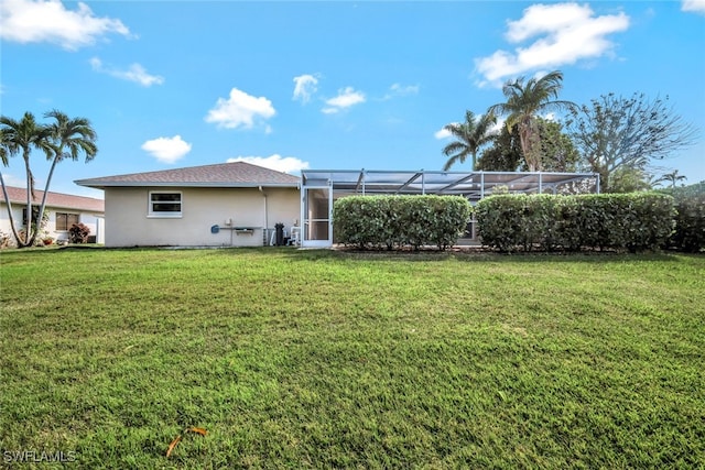 exterior space featuring a lanai, a lawn, and stucco siding