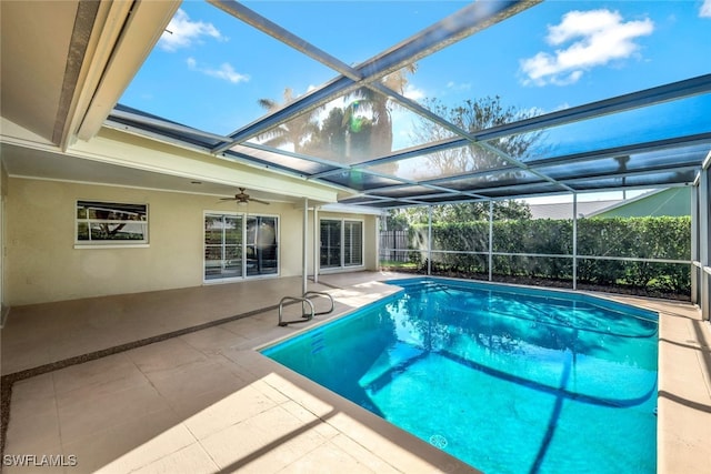 outdoor pool featuring glass enclosure, fence, and a patio