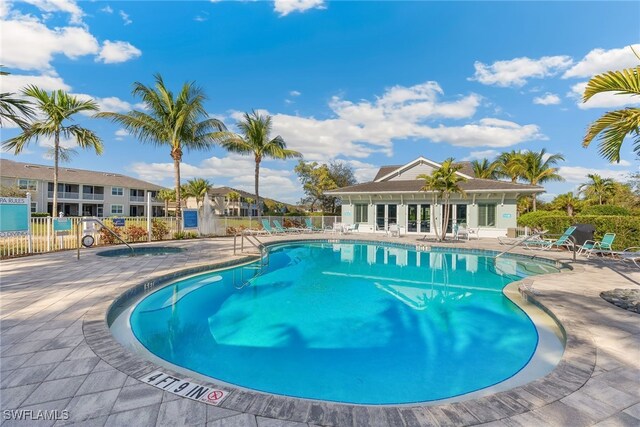 community pool with fence and a patio