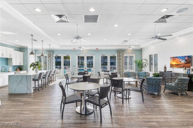 dining space with dark wood-style floors, visible vents, and crown molding