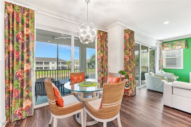 dining space with a notable chandelier, crown molding, dark wood finished floors, and a wealth of natural light