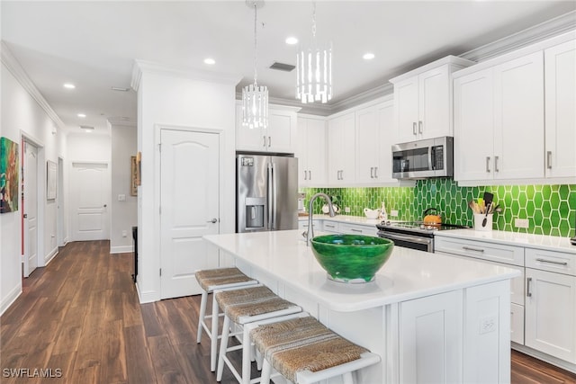 kitchen with stainless steel appliances, light countertops, visible vents, a kitchen island with sink, and white cabinetry