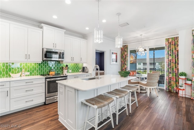 kitchen featuring crown molding, a chandelier, a sink, light countertops, and stainless steel appliances