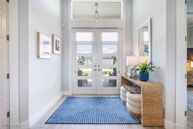 doorway to outside with wood finished floors and baseboards