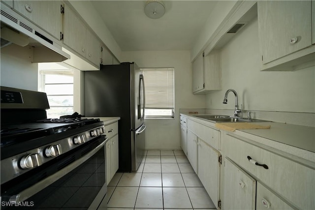 kitchen with light countertops, ventilation hood, gas stove, and a sink