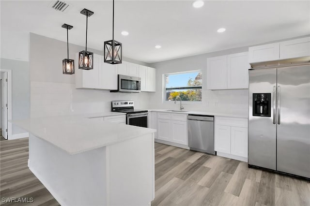 kitchen featuring visible vents, stainless steel appliances, light countertops, and white cabinetry