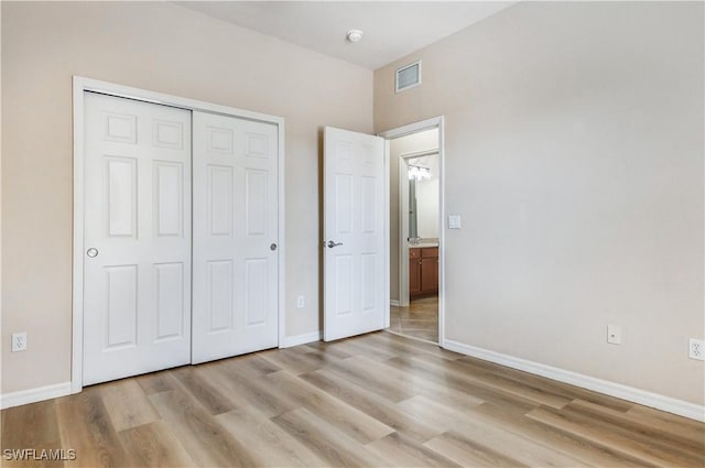 unfurnished bedroom featuring light wood-style floors, a closet, visible vents, and baseboards