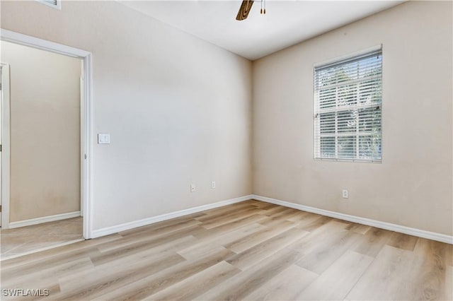 empty room featuring light wood finished floors, ceiling fan, and baseboards