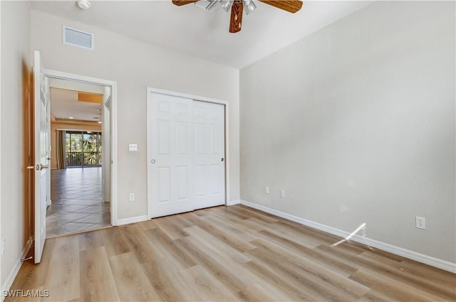 unfurnished bedroom with light wood finished floors, a closet, visible vents, ceiling fan, and baseboards