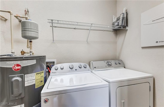 washroom featuring water heater, laundry area, and independent washer and dryer