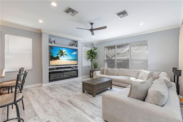 living area with light wood-type flooring, baseboards, visible vents, and ornamental molding