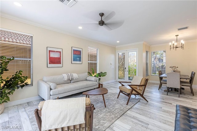 living area featuring light wood-type flooring, baseboards, visible vents, and crown molding