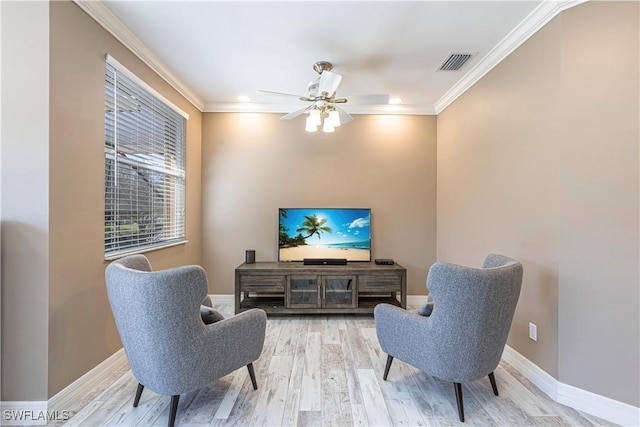 living area featuring baseboards, visible vents, ceiling fan, wood finished floors, and crown molding