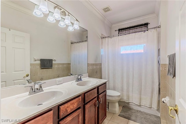 bathroom featuring visible vents, a sink, and tile walls