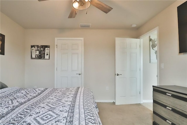 bedroom featuring baseboards, visible vents, a ceiling fan, and light colored carpet