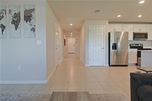 kitchen with light tile patterned floors, visible vents, white cabinets, stainless steel appliances, and light countertops