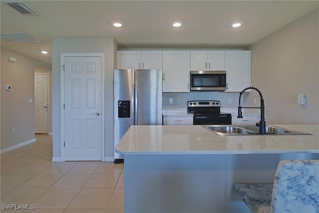 kitchen featuring stainless steel appliances, light countertops, visible vents, and white cabinetry