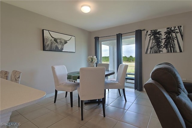 dining space featuring light tile patterned flooring and baseboards