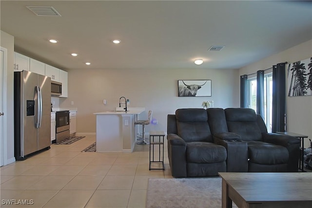 living area with light tile patterned floors, baseboards, visible vents, and recessed lighting