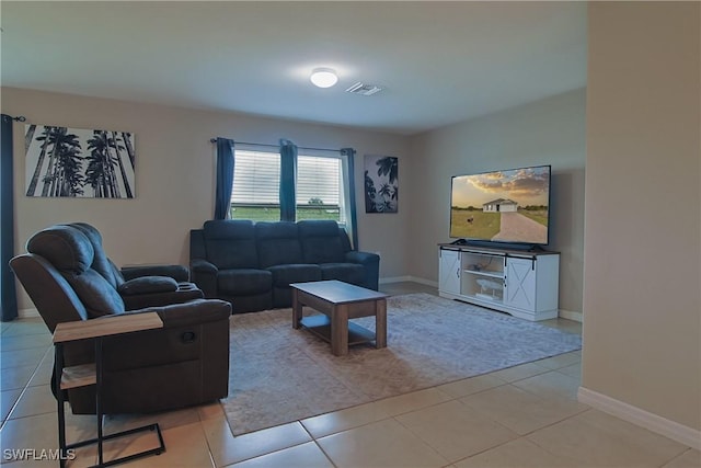 living room with light tile patterned floors, visible vents, and baseboards