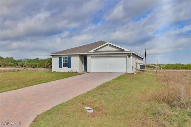 view of front of house featuring a garage, a front lawn, decorative driveway, and stucco siding