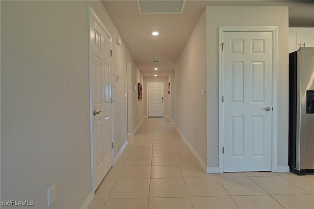 hallway with recessed lighting, visible vents, baseboards, and light tile patterned flooring