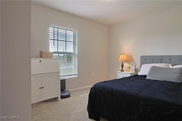 bedroom featuring baseboards and light colored carpet