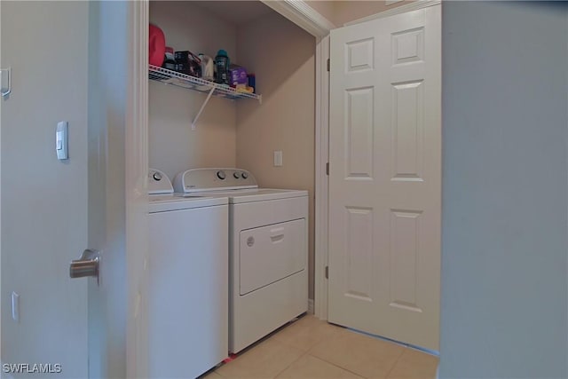 washroom with light tile patterned floors, laundry area, and washer and clothes dryer