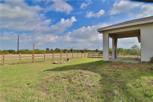 view of yard with a fenced backyard and a rural view