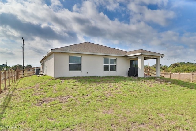 rear view of property featuring stucco siding, a fenced backyard, cooling unit, and a yard