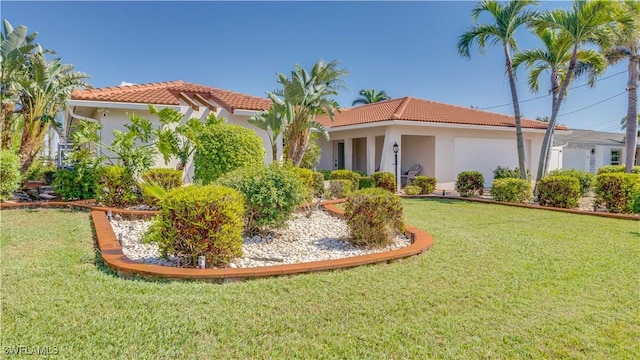 view of front of home with a tiled roof, a front yard, and stucco siding