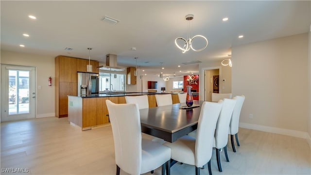 dining space with stacked washer / drying machine, a healthy amount of sunlight, light wood-style flooring, and recessed lighting