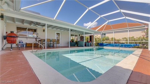 pool with glass enclosure, ceiling fan, and a patio