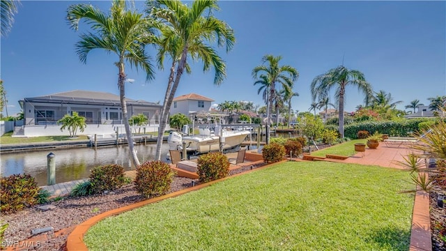 view of yard featuring a water view, a boat dock, and boat lift