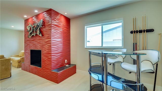 dining room with recessed lighting, a fireplace, baseboards, and wood finished floors