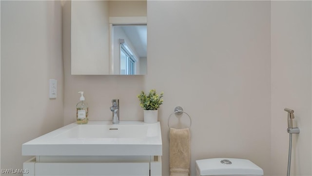 bathroom featuring toilet and vanity