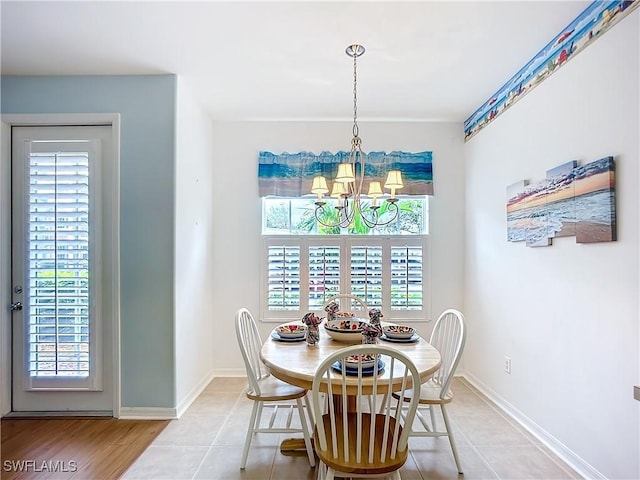 dining space with light tile patterned floors, baseboards, and a chandelier