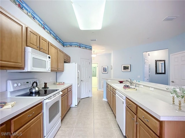 kitchen featuring brown cabinets, light tile patterned floors, light countertops, a sink, and white appliances