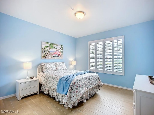 bedroom with light wood-type flooring and baseboards