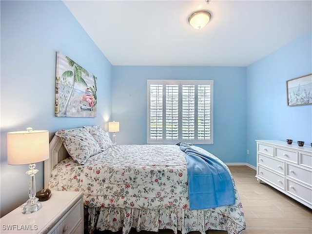 bedroom featuring light wood-style floors and baseboards