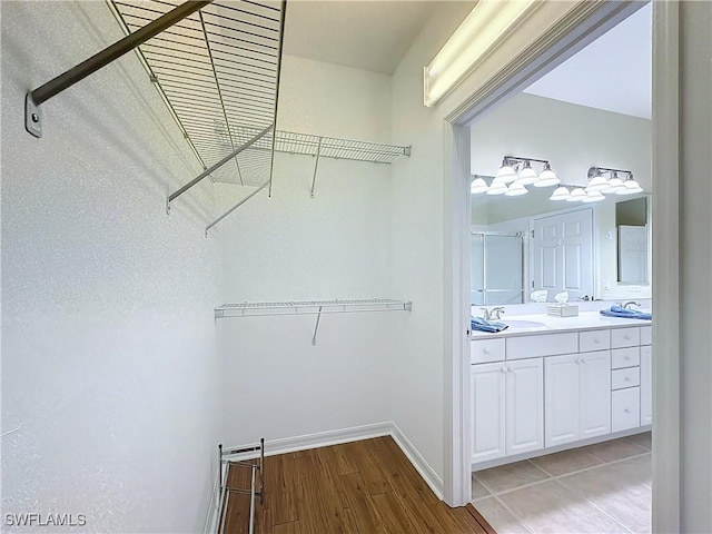 walk in closet featuring light wood-type flooring and a sink