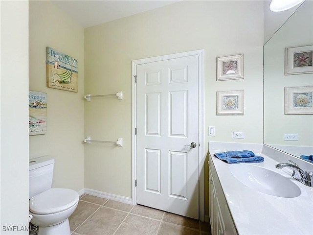 bathroom featuring tile patterned flooring, baseboards, vanity, and toilet