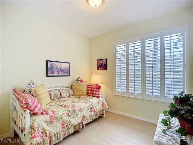 bedroom featuring light wood finished floors and baseboards