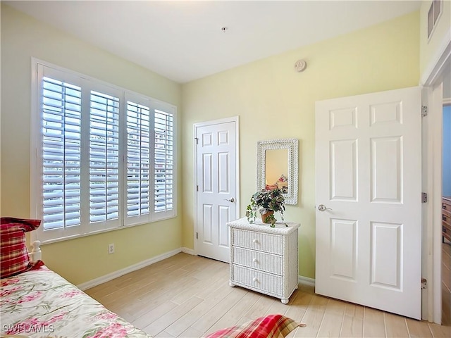 bedroom featuring light wood-type flooring, visible vents, and baseboards