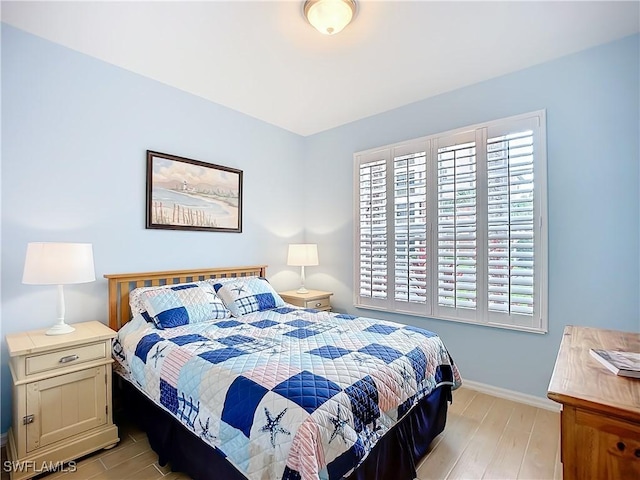 bedroom with light wood-type flooring and baseboards