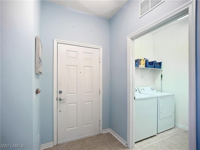 laundry room with light tile patterned flooring, laundry area, visible vents, baseboards, and washer and clothes dryer